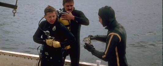 Bob Marx assists Drew Ruddy, while Jim Batey examines beer mug after dive on the Georgiana.