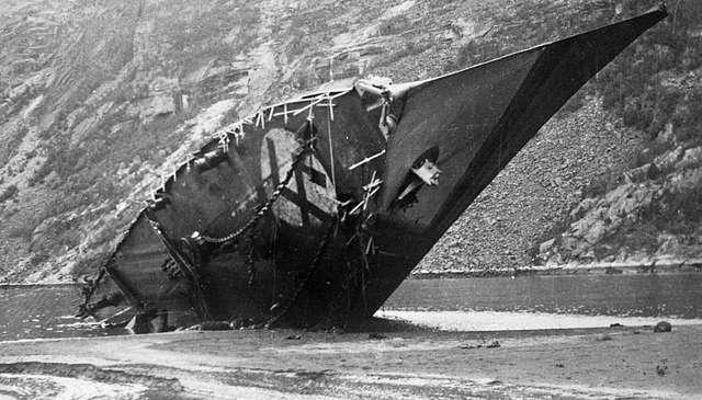 Bow of scuttled ship sticking out of water near fiord 