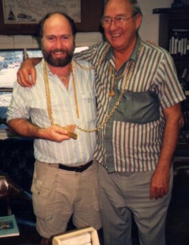 photo of underwater archaeologist, Dr. E. Lee Spence and treasure hunter Mel Fisher draped with gold chains salvaged from a shipwreck